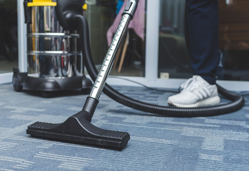 someone vacuuming the carpet in a office space